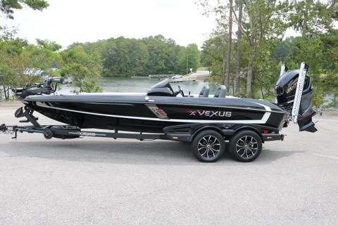 A boat is parked on the street with a person standing next to it.