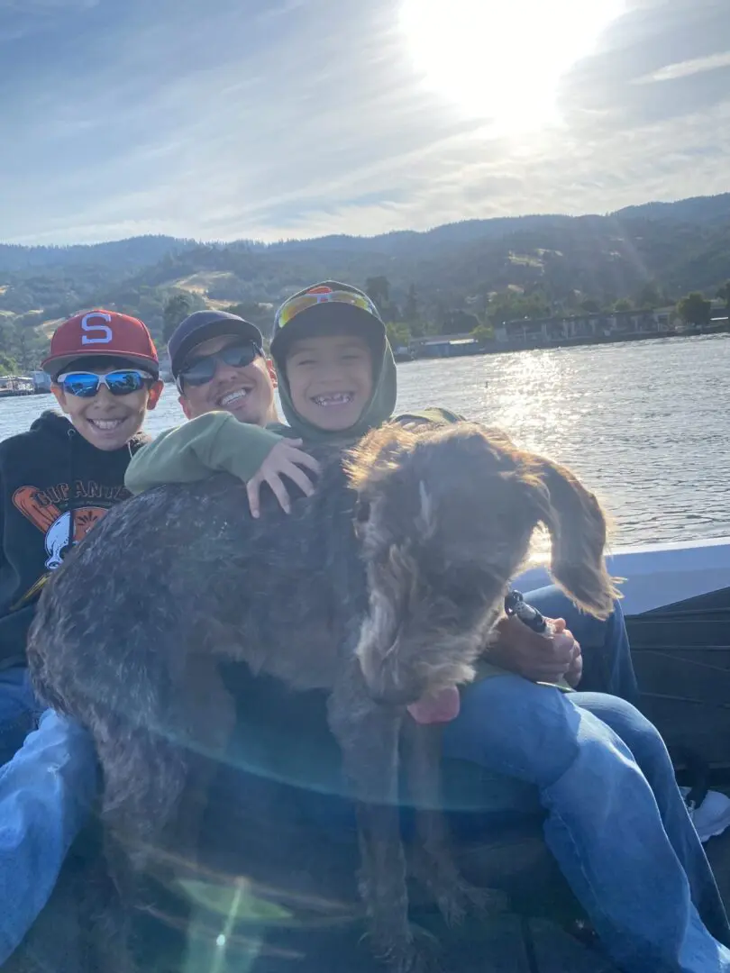 Happy family boating with their dog.