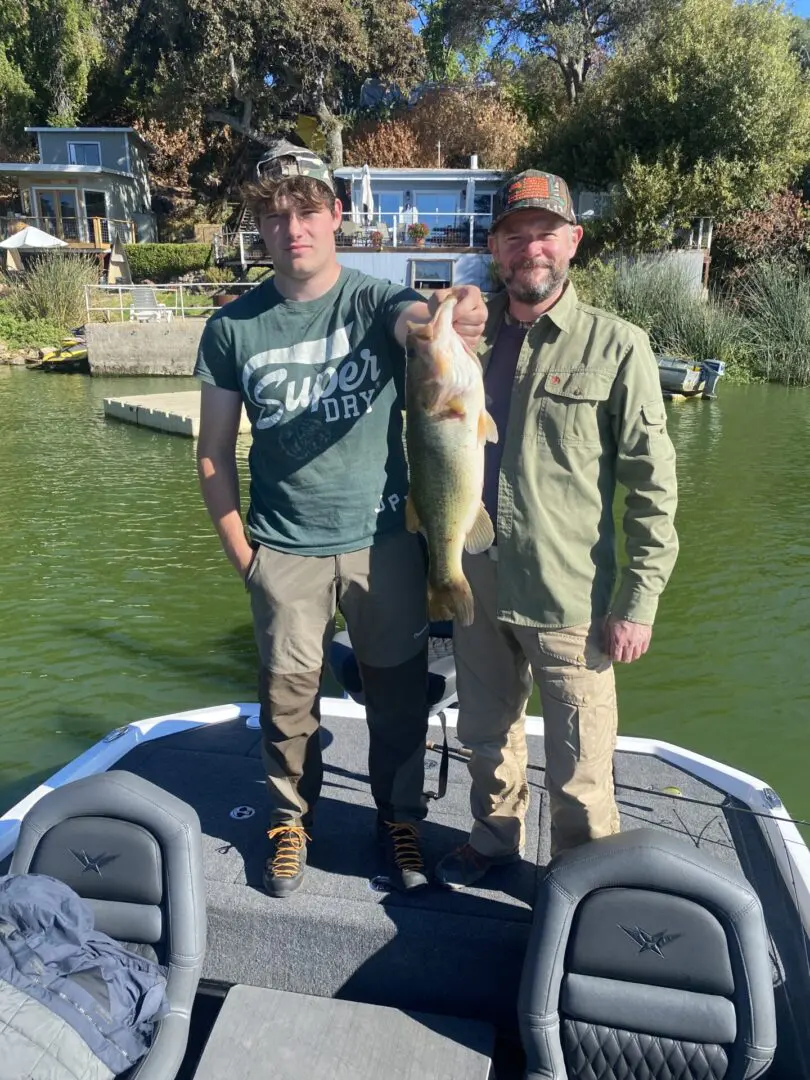 Father and son holding large bass.