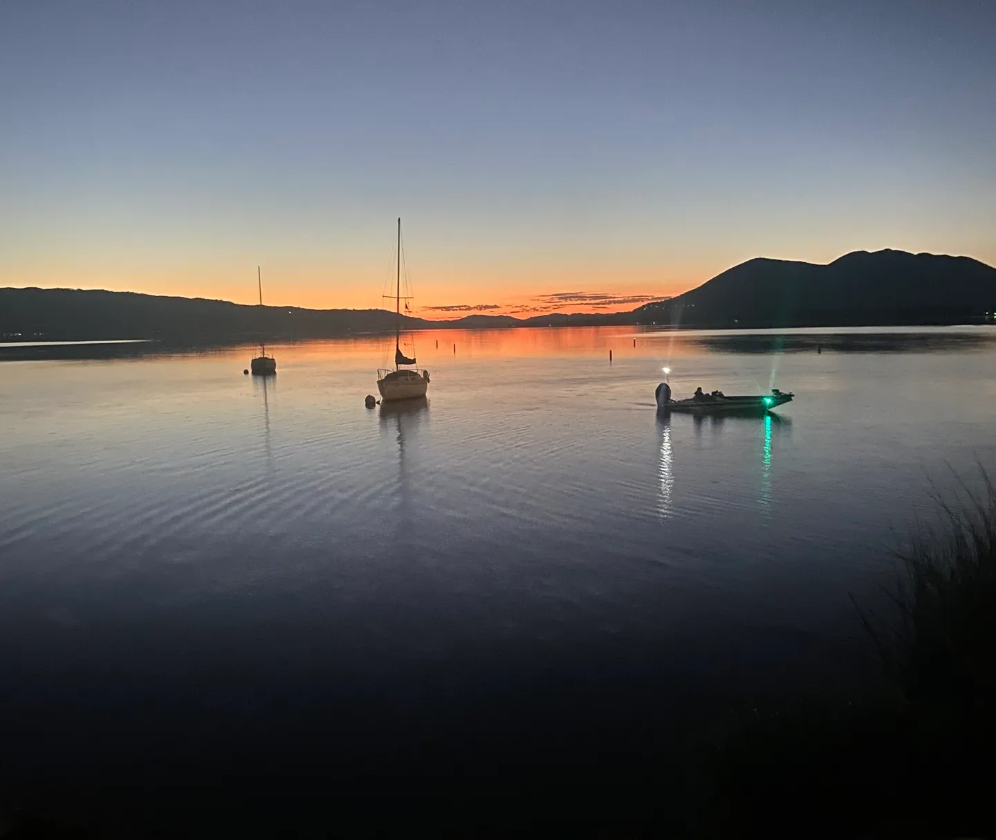 Sunset lake scene with boats.