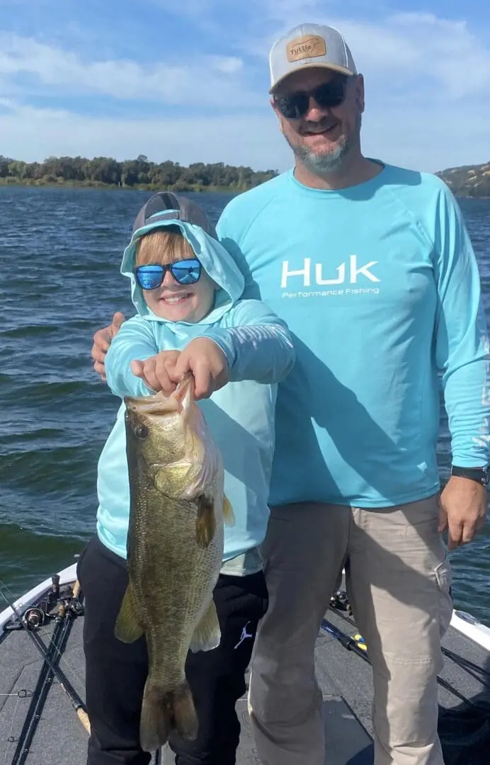 Boy and dad holding a large bass.