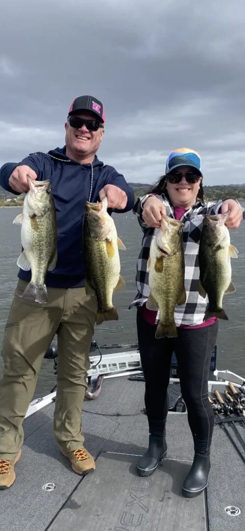 Two anglers showing off their bass catch.